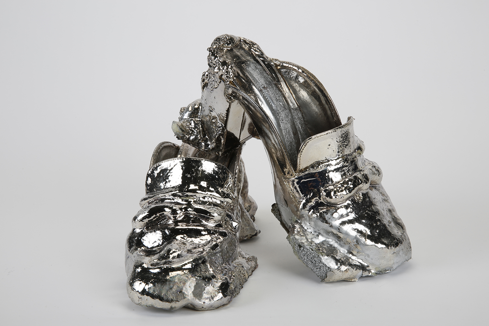 Pair of chrome coloured slip on heeled shoes with polyurethane additions, also coloured chrome.
